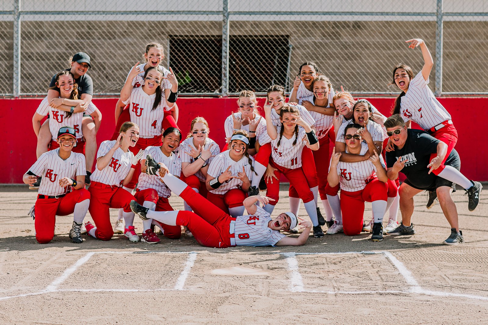 Coach McCarty's KU Pelicans softball team — 14 of 18 players are freshmen. 7-11 with five games left. The 'winningest team in KU history' building from resilience, attainable goals, and small confidence-builds toward big future seasons.